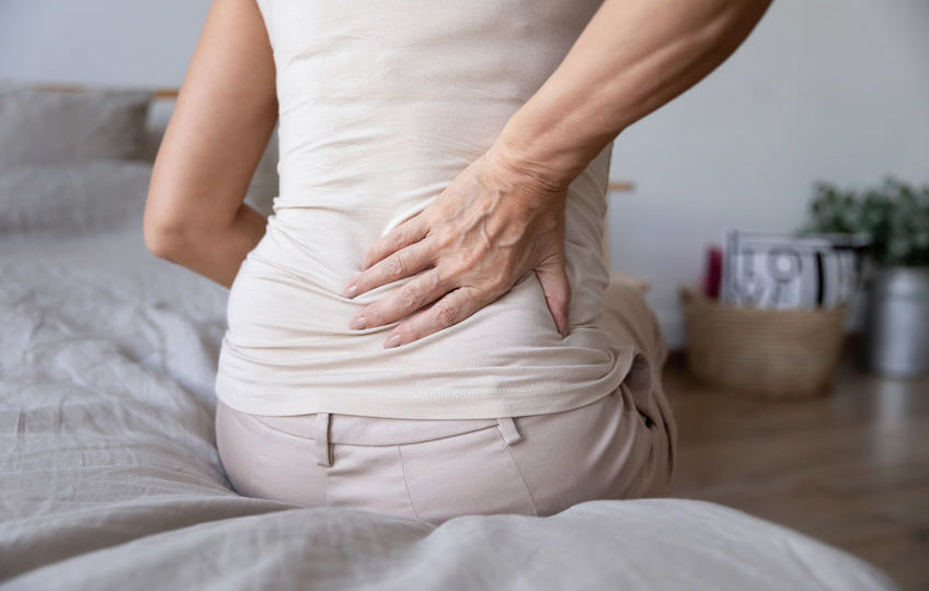 Old mature woman sit on bed touch back feel backpain